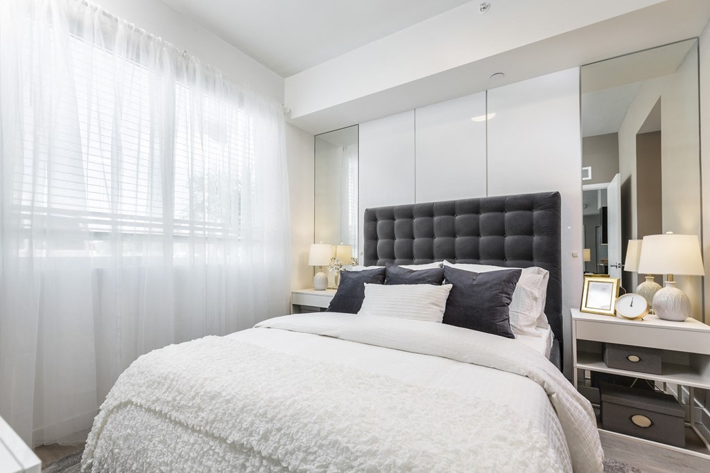 a bedroom with a large bed and a mirror