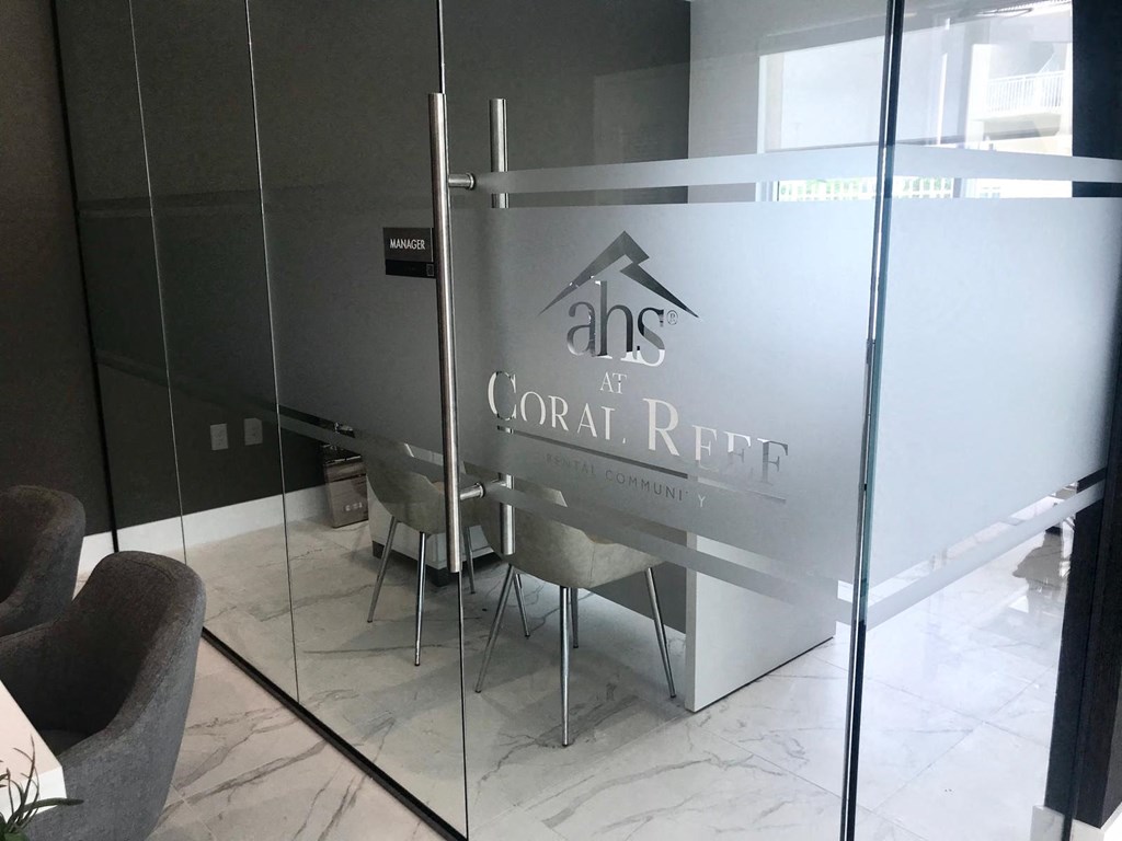 a glass walled room with a table and chairs in it