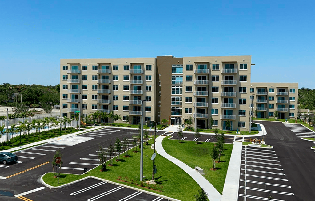 an empty parking lot in front of an apartment building