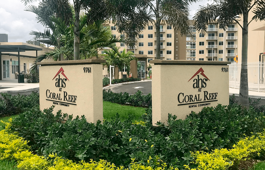 two signs that read coral reef in front of a building