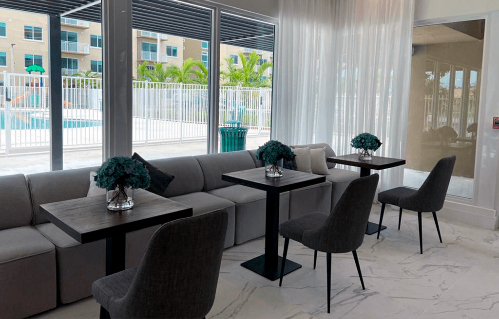 a living room with tables and chairs in front of a window