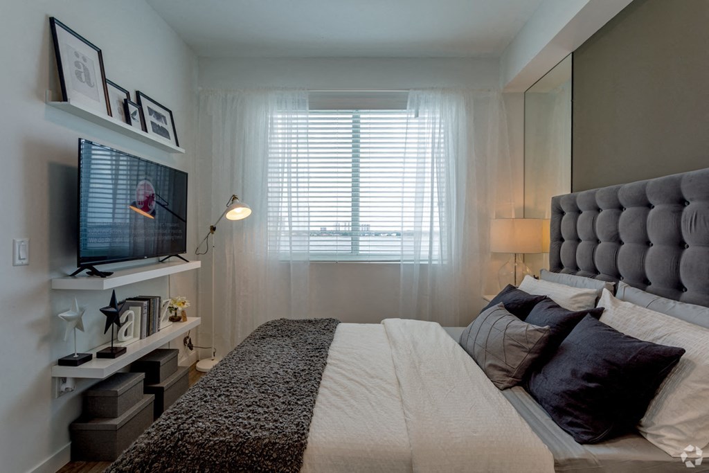 a bedroom with a large bed and a window