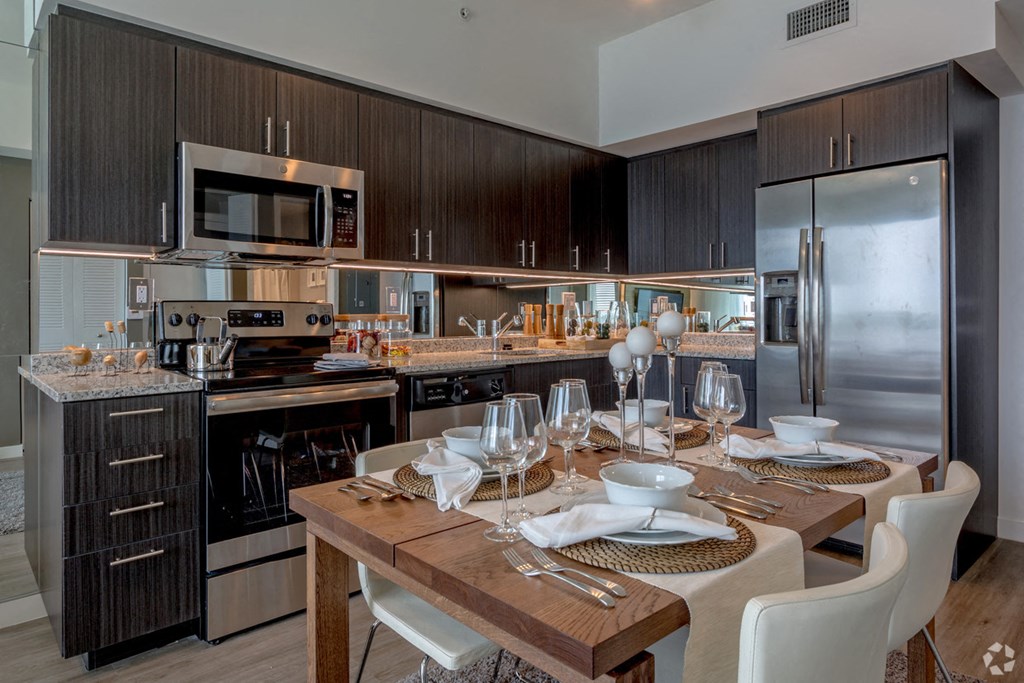 a kitchen with stainless steel appliances and a dining table