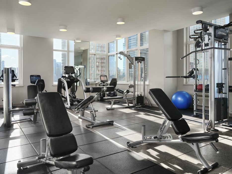 A gym with a variety of equipment including weights and machines.