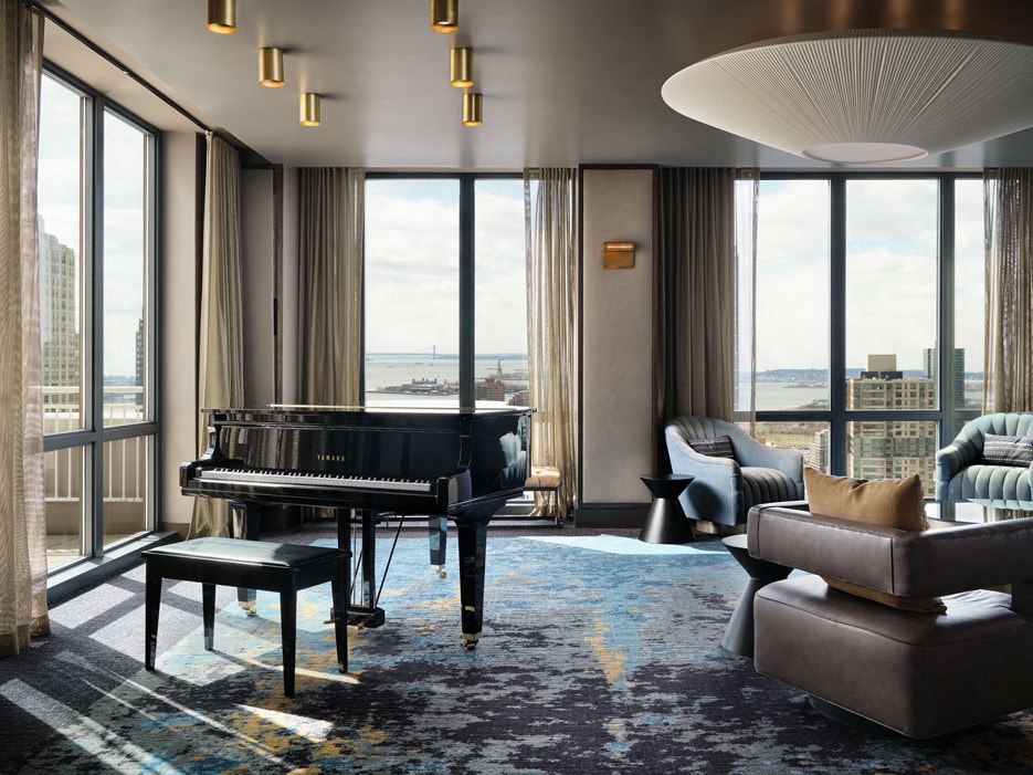 A grand piano sits in a room with a view of the city.