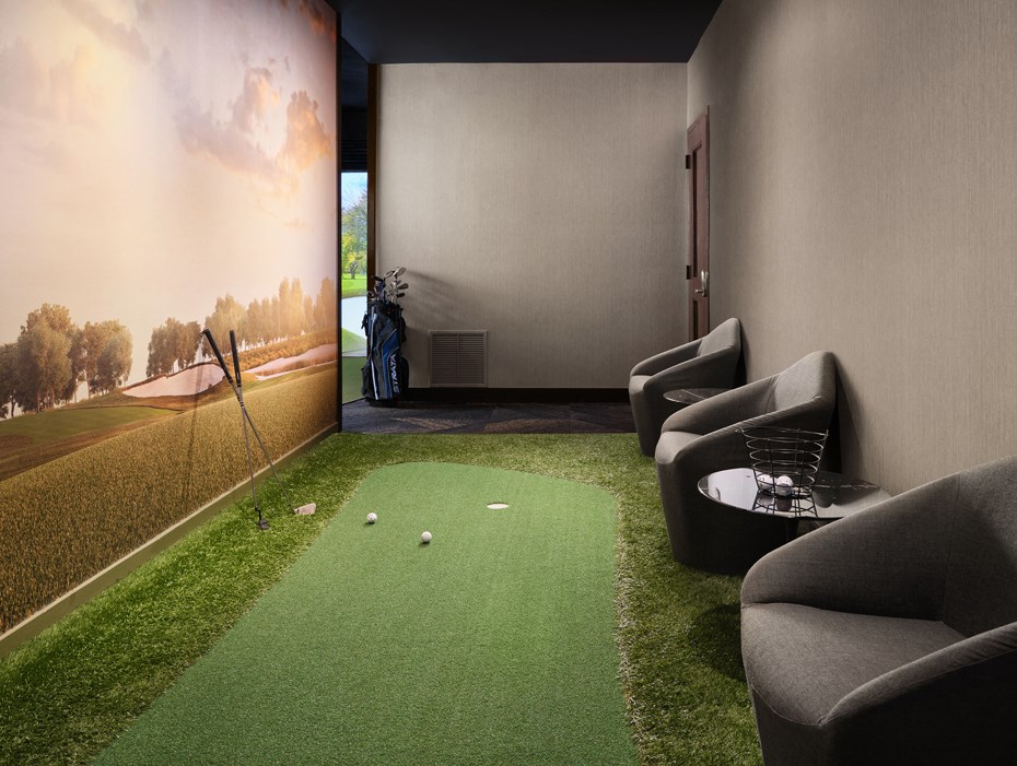 A room with a green carpet and a wall mural of a landscape.
