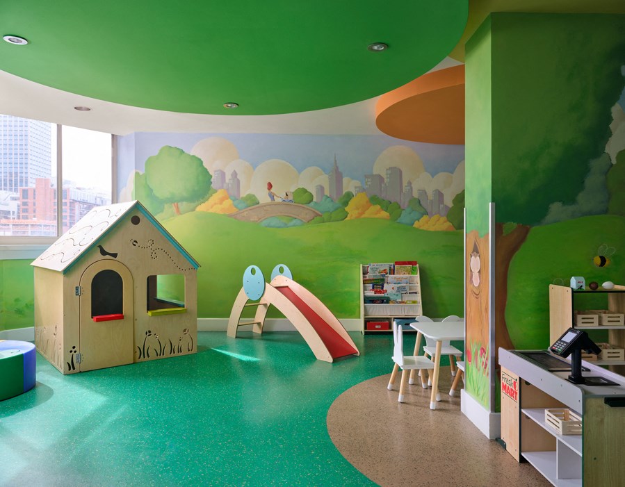 A play area with a slide, a playhouse and a table.