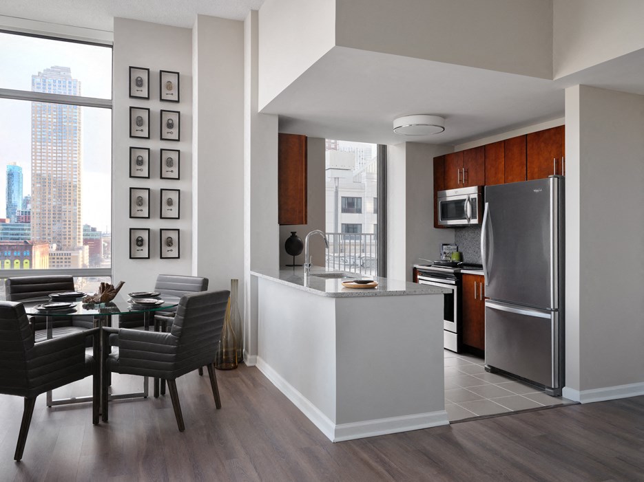 a kitchen and dining room with a large window and a stainless steel refrigerator