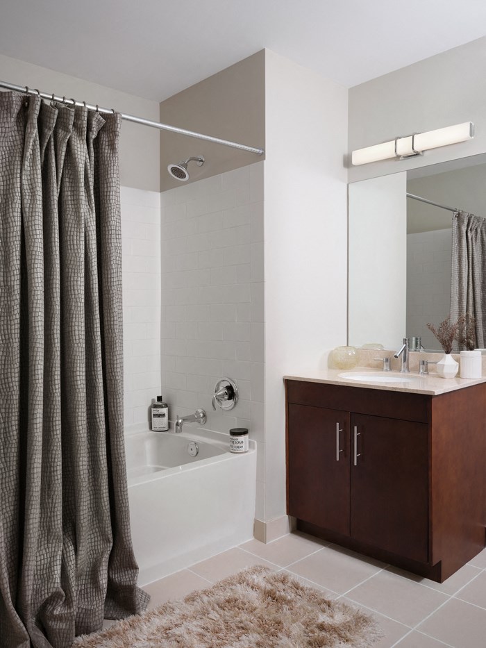 a bathroom with a bath tub and a sink and a mirror