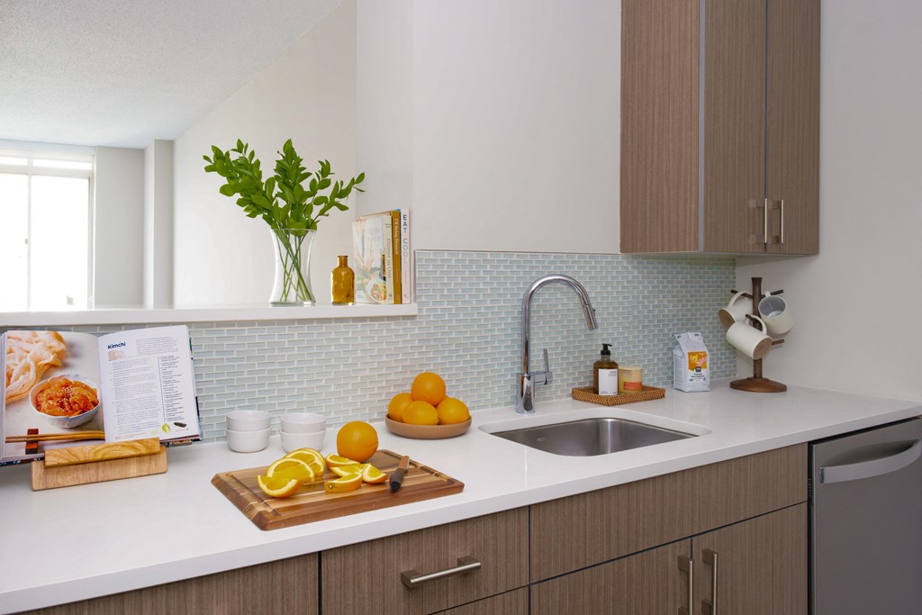 A kitchen with a cutting board of oranges on the counter.