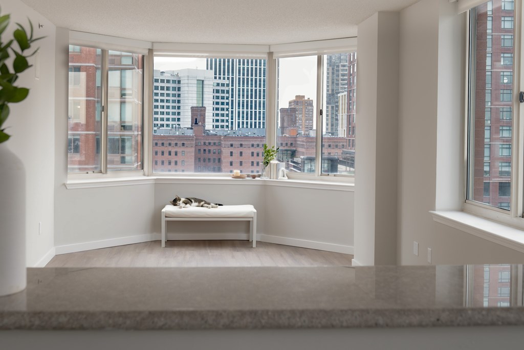 A room with a bench and a view of the city.
