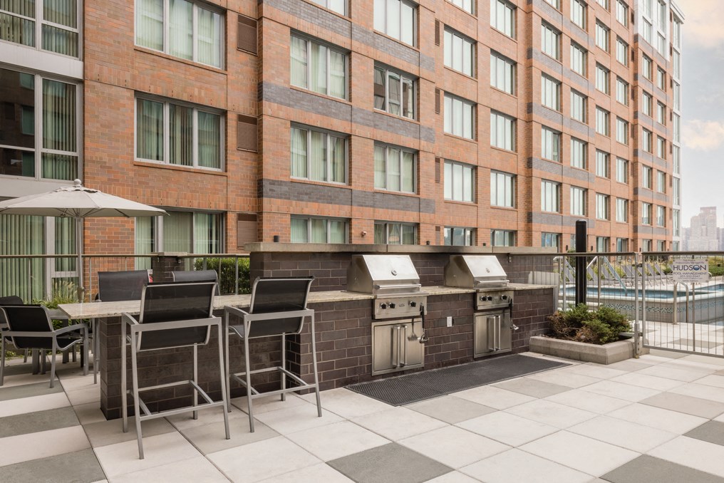 a patio with a table and chairs in front of a building