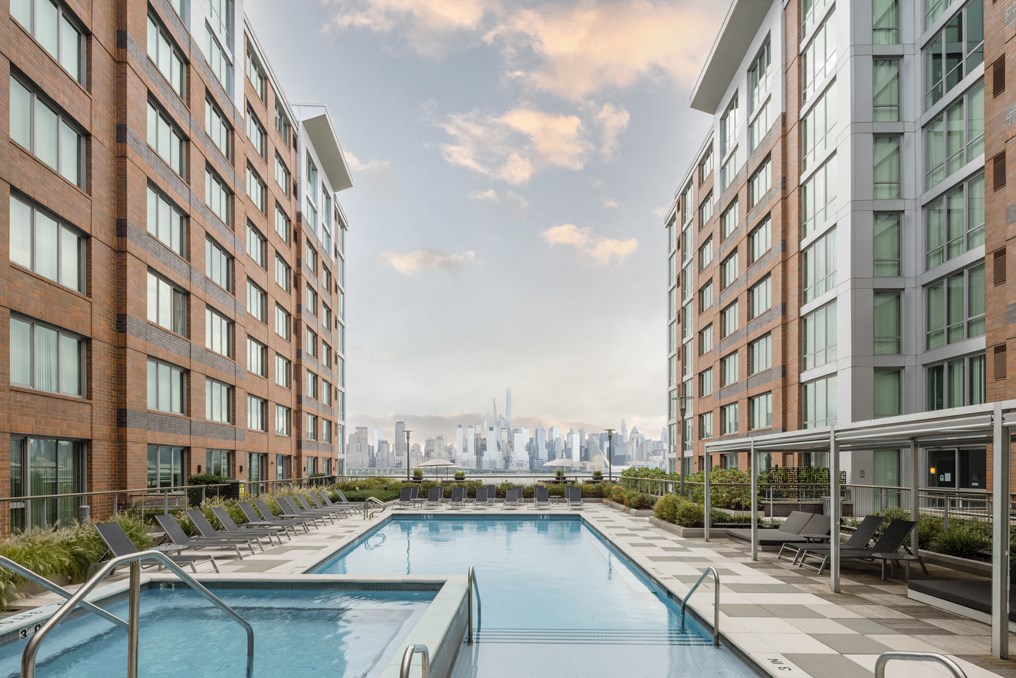 the pool of an apartment building with a view of the city