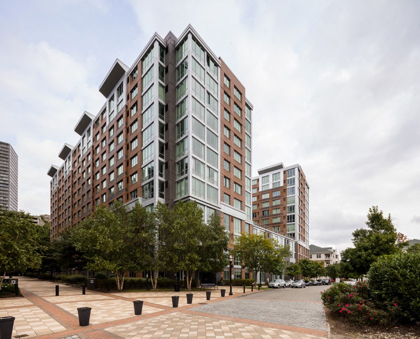 an apartment building on a city street with trees
