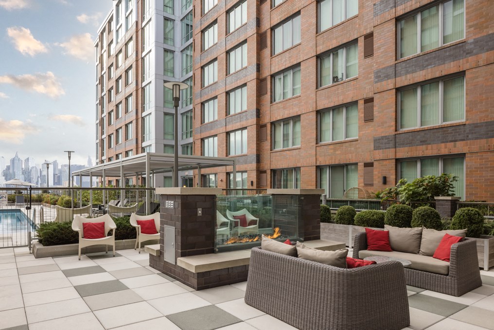 an outdoor terrace with couches and chairs in front of a building
