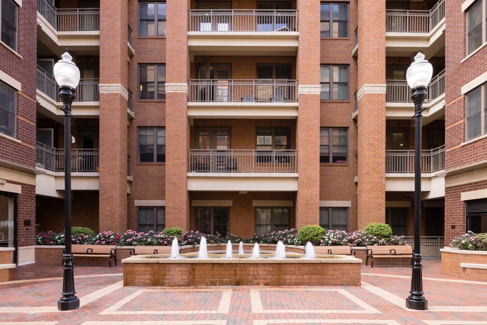 a courtyard with a fountain in front of a building