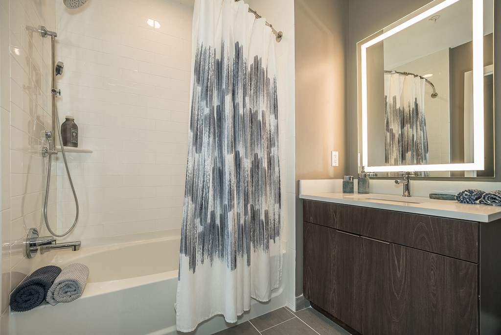 a bathroom with a shower and a sink and a mirror