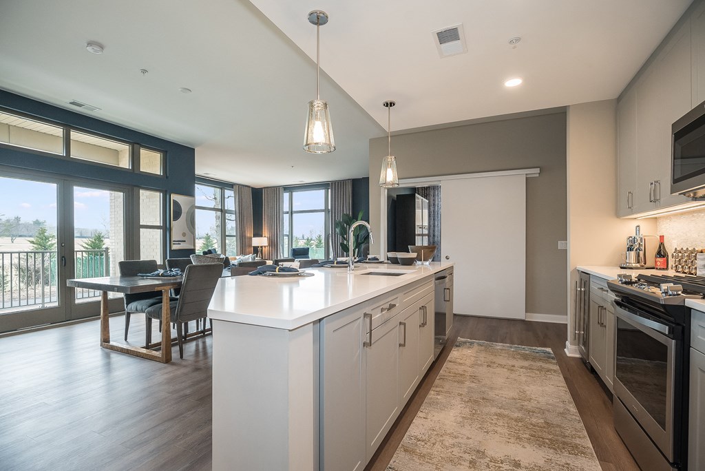 an open kitchen and living room with a large white counter top