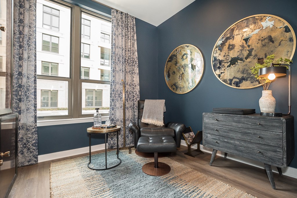 a living room with blue walls and a chair and a dresser