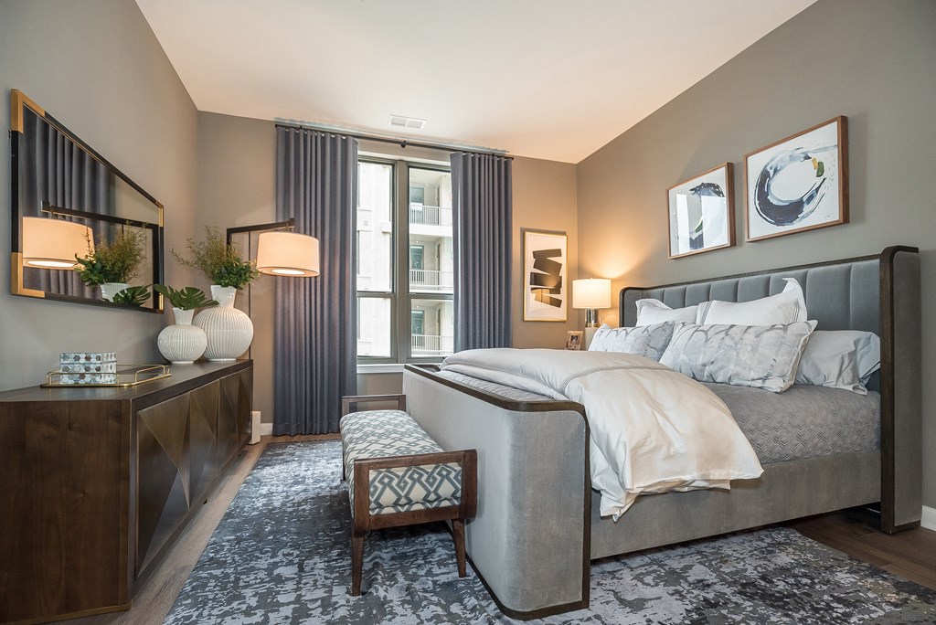 a bedroom with a bed and a dresser and a window