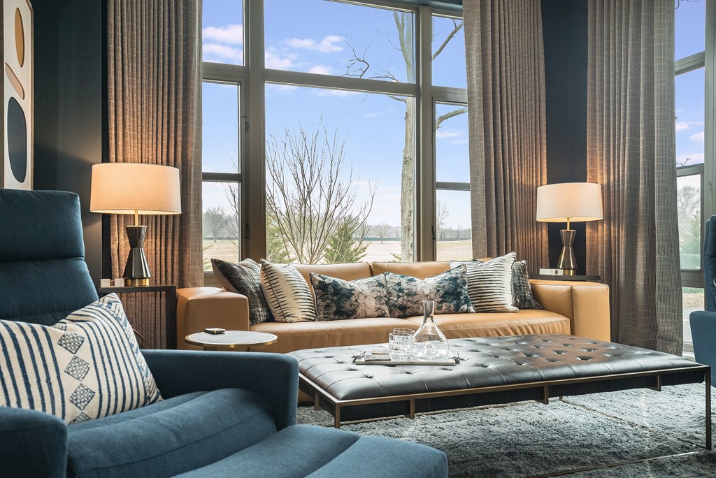 a living room with couches and a coffee table and large windows