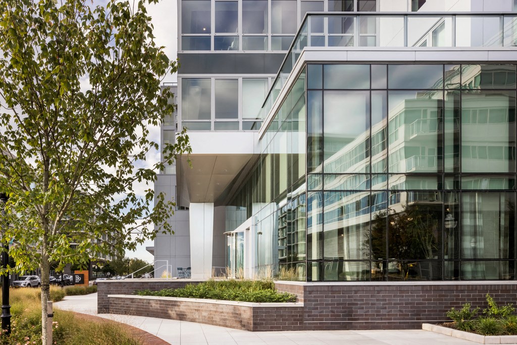 a building with large glass windows and a walkway in front of it