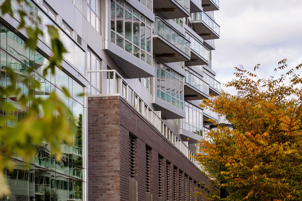 the facade of an apartment building with trees in the foreground