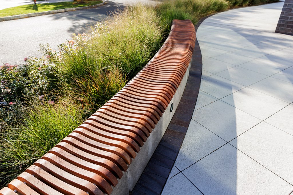 a red and white striped brick retaining wall in front of a sidewalk