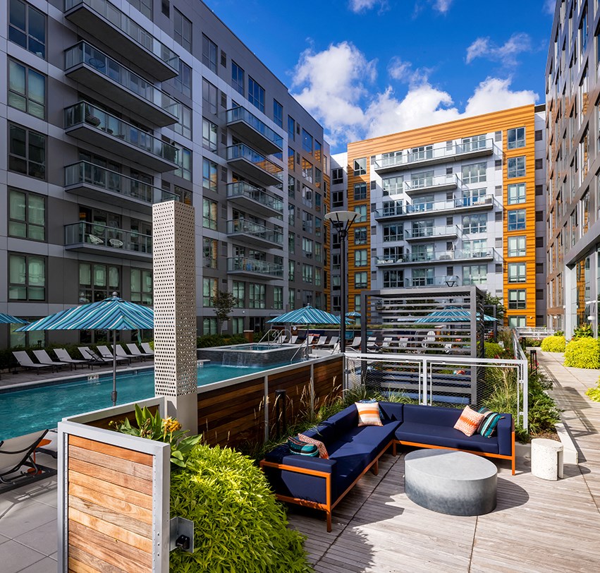 a pool and lounge area on a balcony of an apartment building