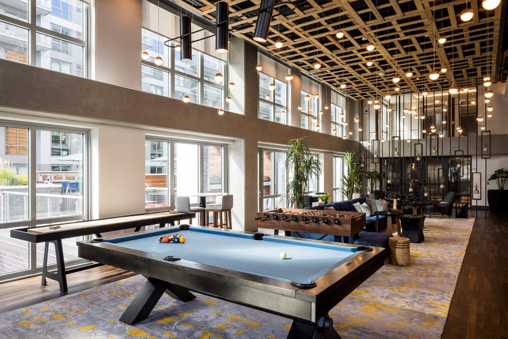 a pool table in a lobby of a building with large windows