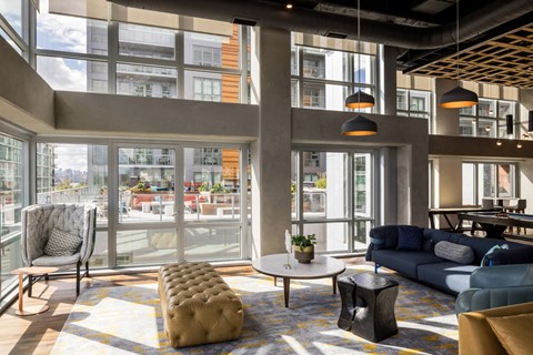 a living room with couches and chairs and large windows