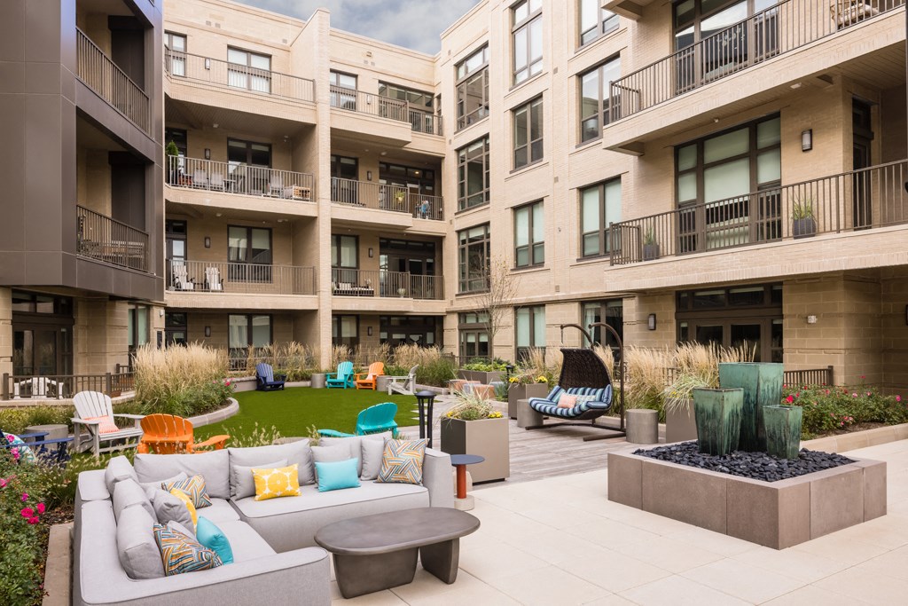 a communal area with couches and chairs in an apartment complex