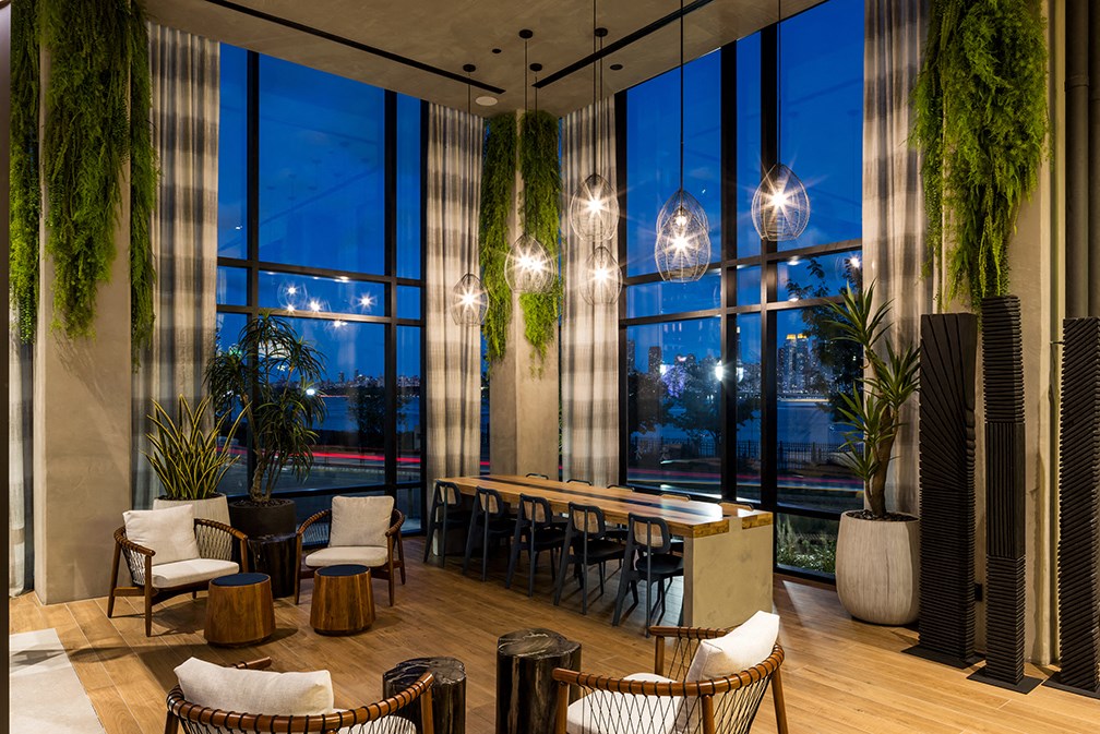 a lounge area with chairs and tables and large windows