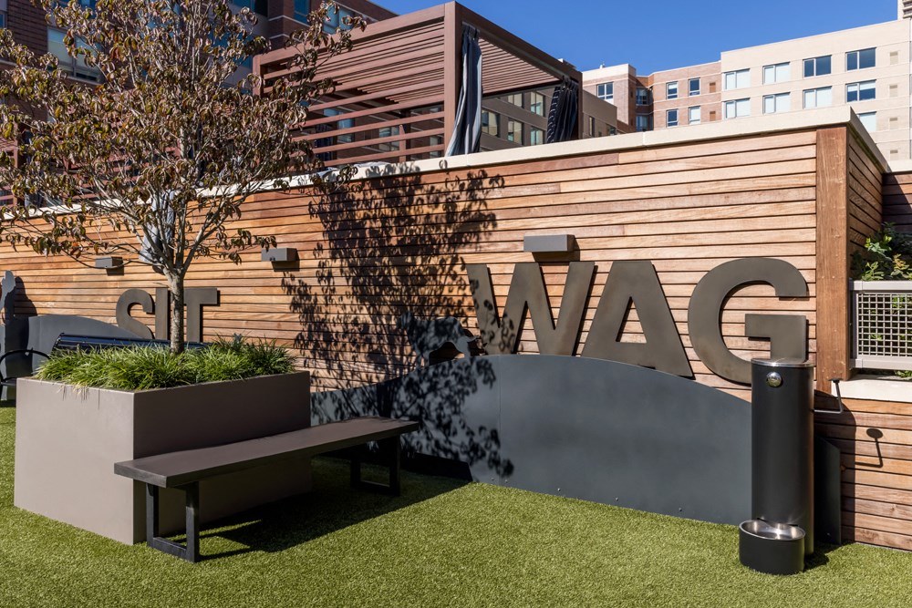 a seating area with a bench and a sign on a building