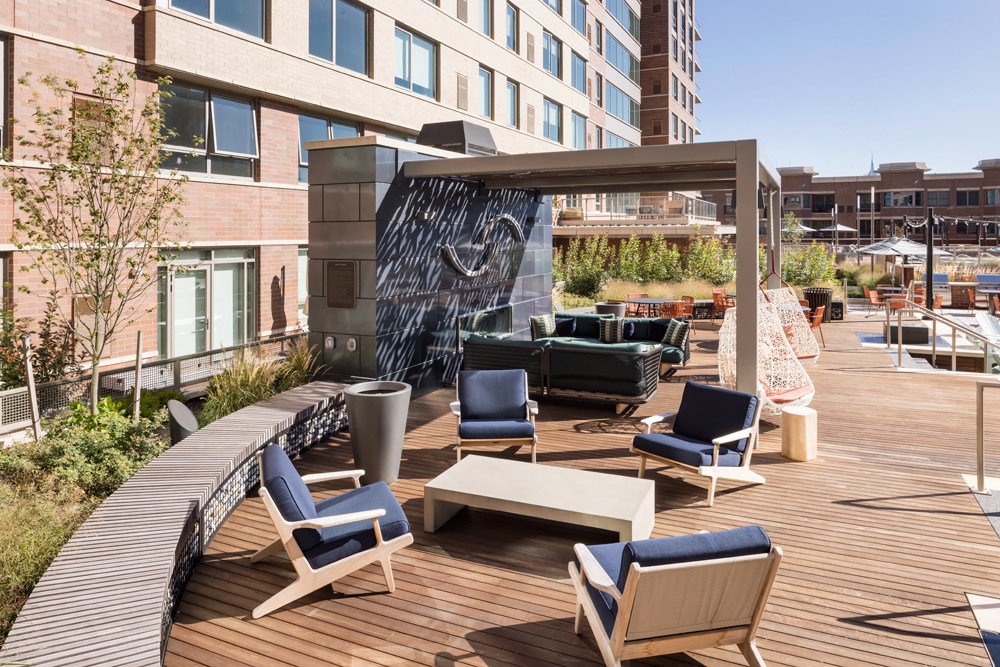 a patio with chairs and tables and a fountain on a building