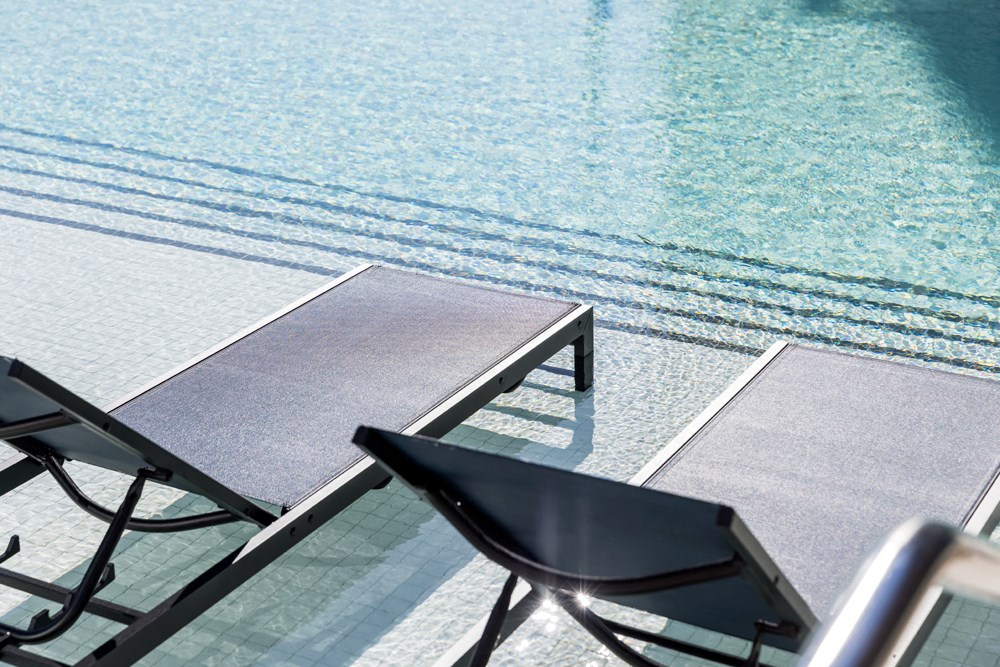 a swimming pool with a table and chairs next to it