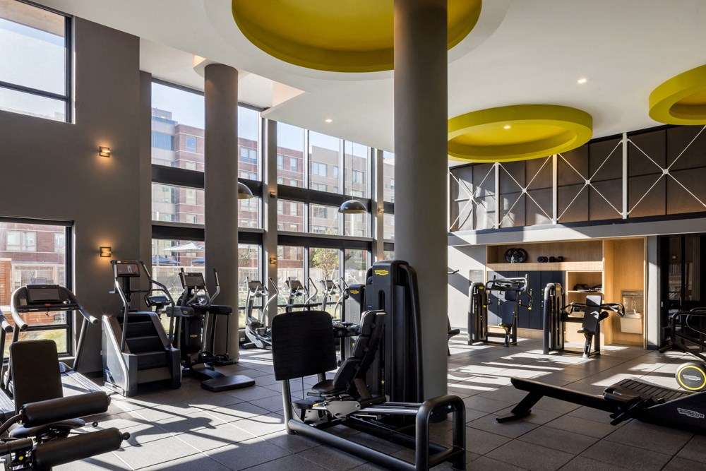 a gym with cardio equipment and windows in a building