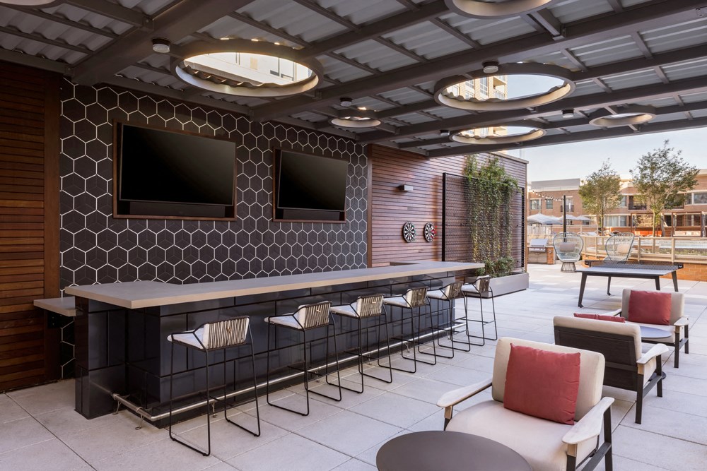 a restaurant with tables and chairs and a bar with televisions