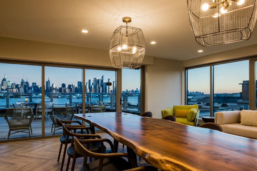 a dining room with a table and chairs and a view of the city