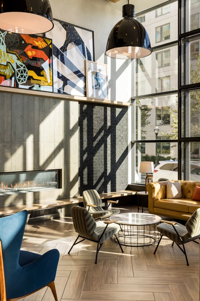 a living room with a fireplace and chairs and tables