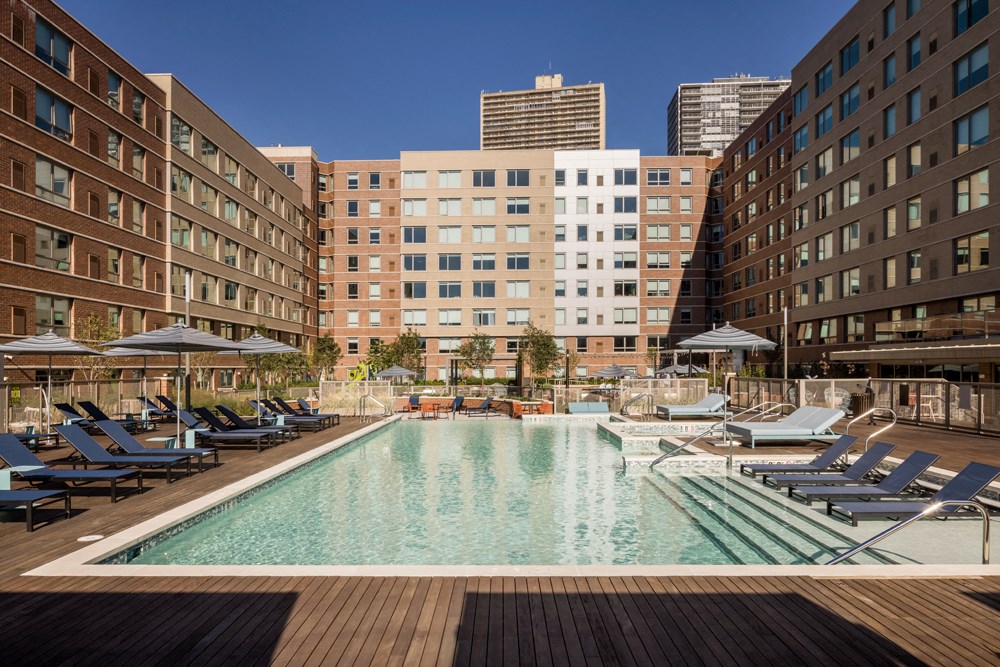 a swimming pool with lounge chairs and umbrellas in a large building