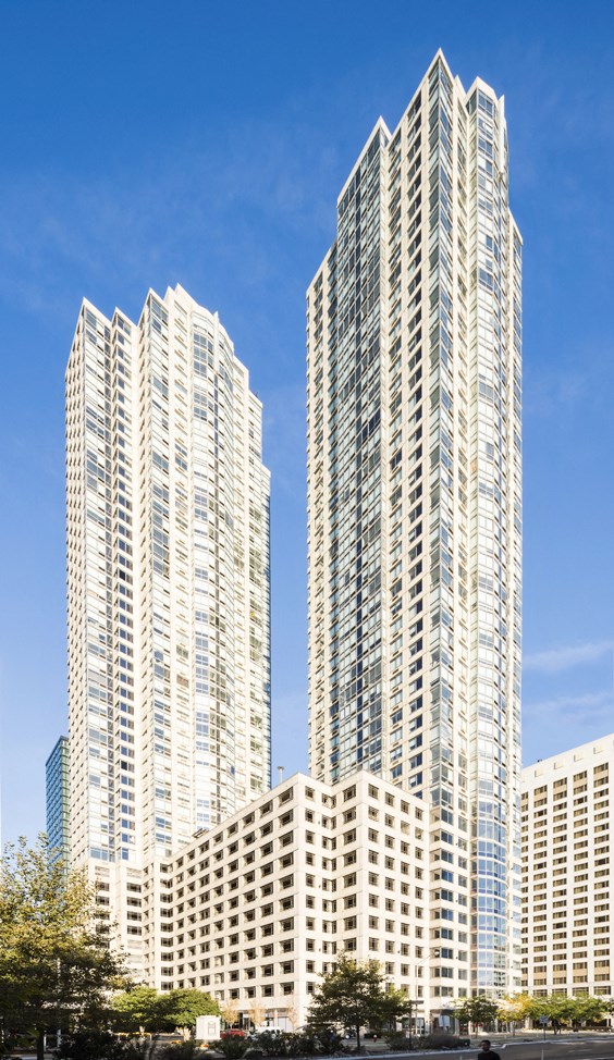 two tall white skyscrapers with a blue sky in the background
