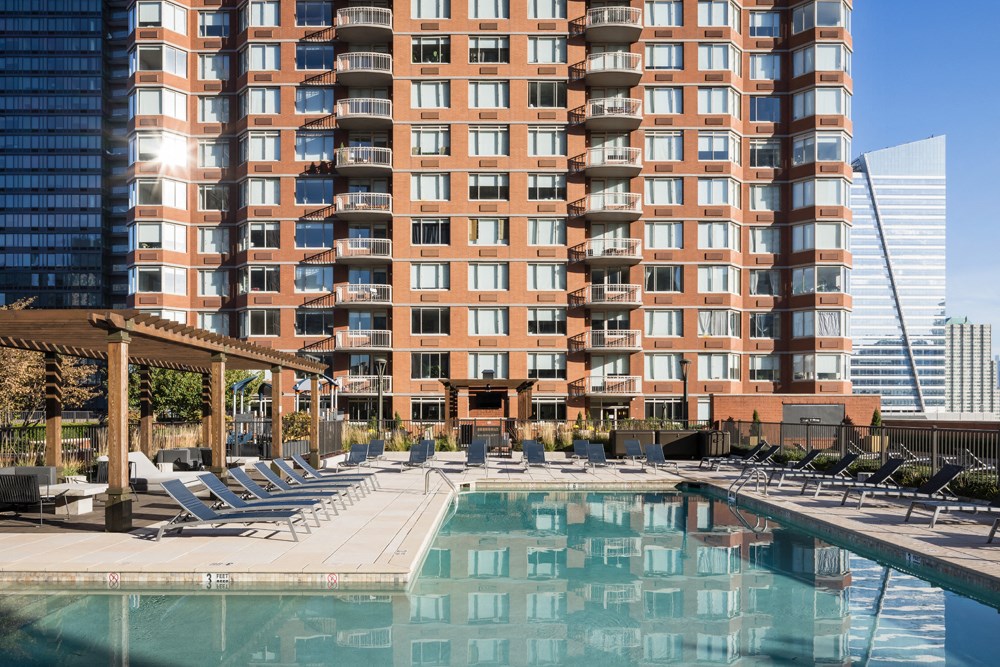 a swimming pool at a hotel in front of a tall building