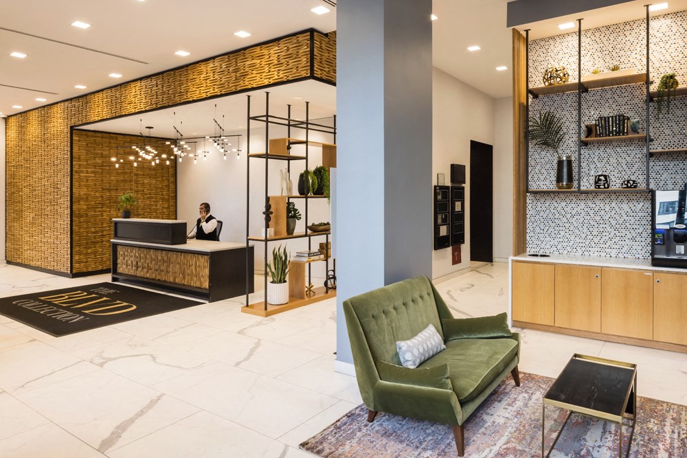 the lobby of a hotel with a green chair and a reception desk