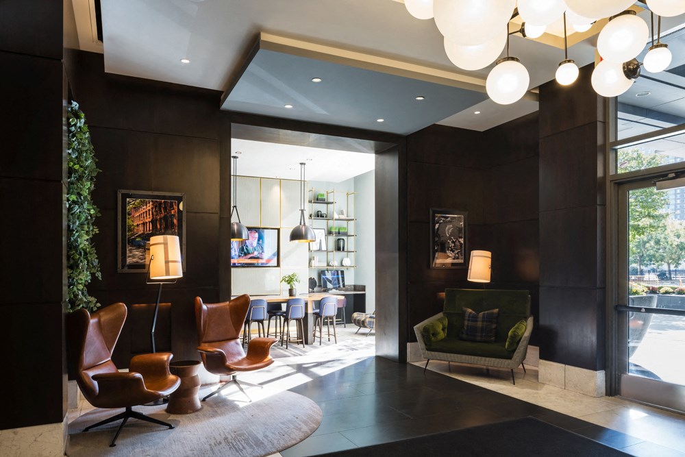 A modern living room with a large window and a green armchair.