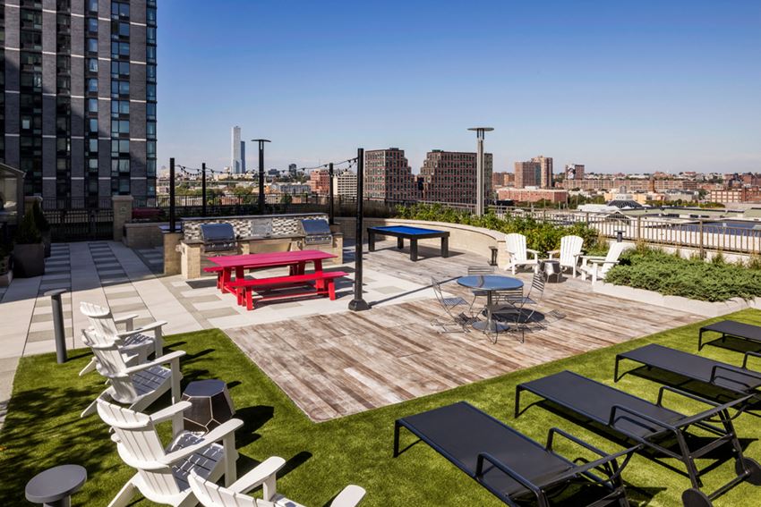 a roof deck with tables and chairs and a view of the city