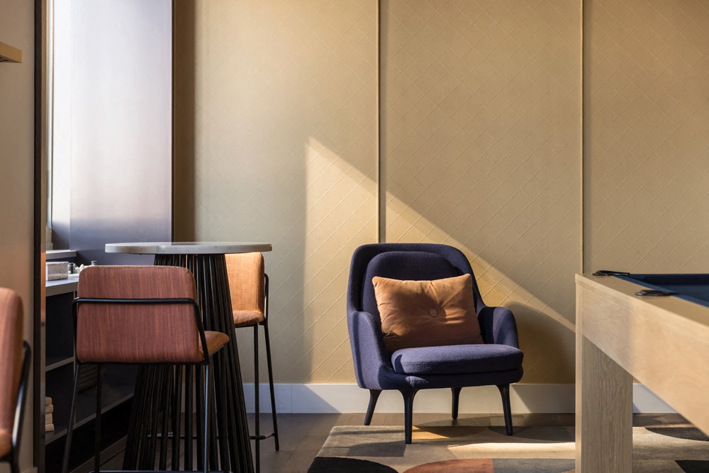 a blue chair with a pillow in a room with tables and chairs