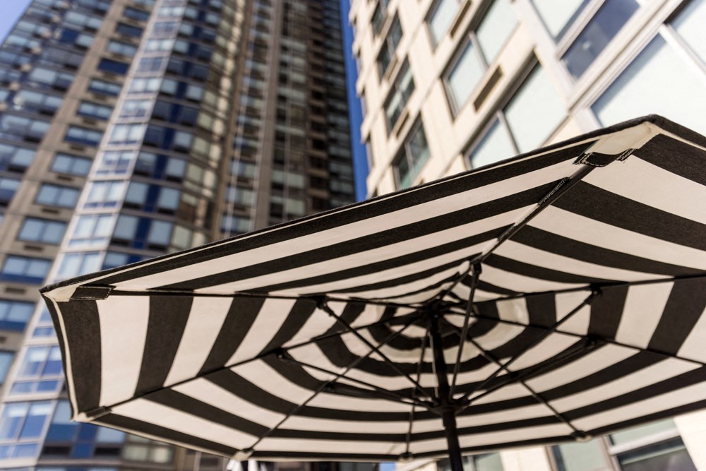 a black and white striped umbrella in front of tall buildings