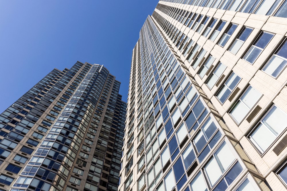 two tall buildings with a blue sky in the background