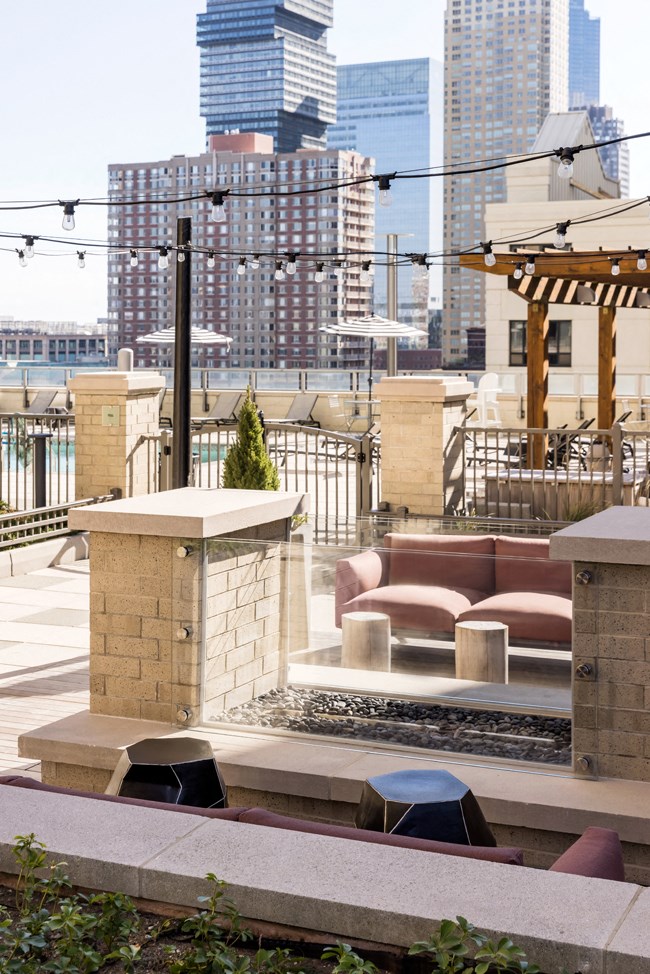 a seating area on the roof of a building with a city in the background